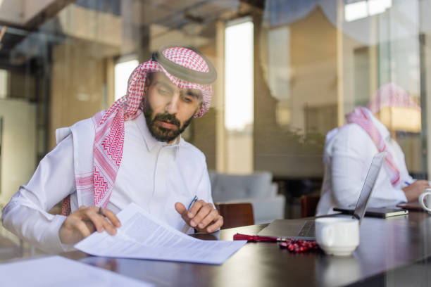 Saudi legal professional reviewing commercial contracts